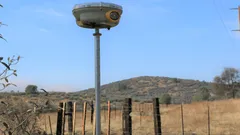 Dispositivo tecnológico en campo con colinas y cielo despejado en México