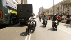 Motociclistas en una calle urbana con presencia policial en México