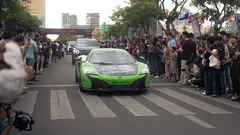 Auto deportivo verde en evento Gumball 3000 en Camboya entre multitud