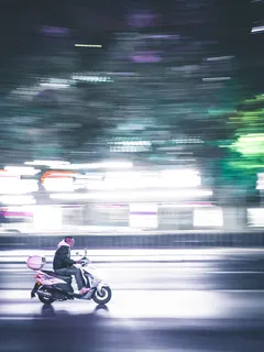 Persona conduciendo motocicleta en calle urbana de ciudad